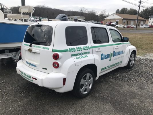 The Back of a White Color Van With Clean in Between Printed