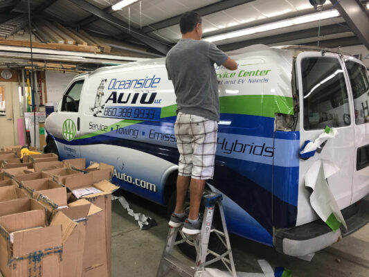 A Man Installing Prints on a Vehicle