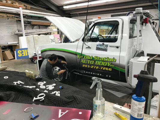 A Person Working on Vehicle Printing in Progress