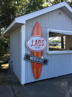 A LADS Merch Hut Sign Board in Surf Board Model