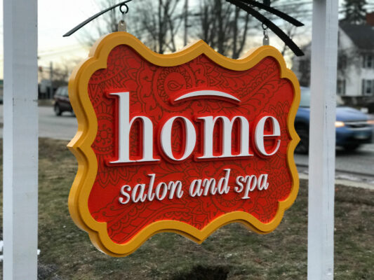 A Home Salon and Spa Sign Hanging Outside