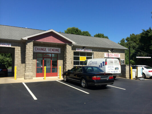 A Change and Vending Sign With a Parking Lot