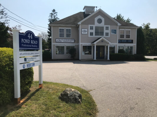 The Front of a Large House With a Board