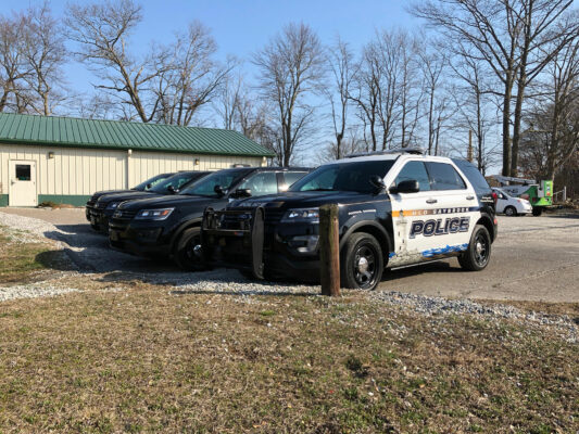 A Line of Police Vehicles Parked Outside