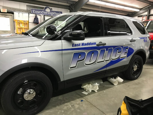 The Side of a White Car With Police Sign