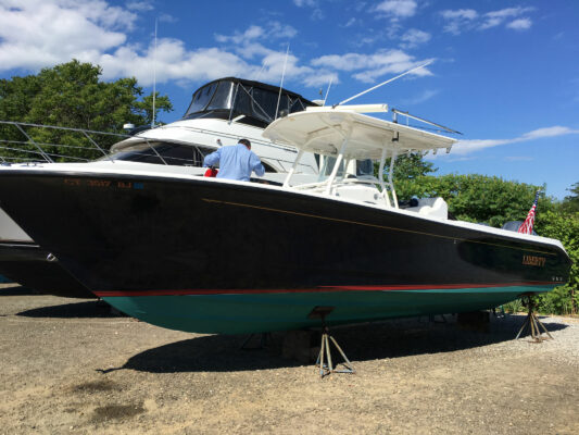 A Boat With Black Color Hull Docked on Land