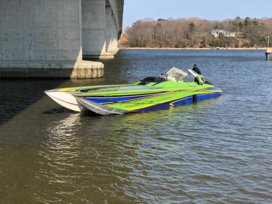 A Green and Blue Tone Boat Sailing Under a Bridge