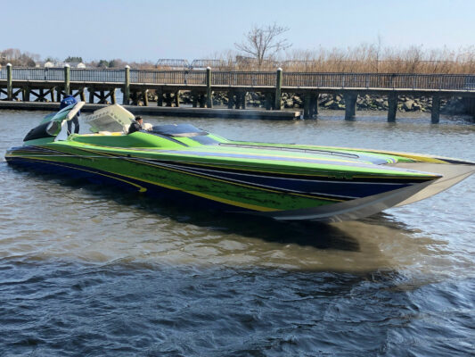 A Green and Blue Boat Still on Water