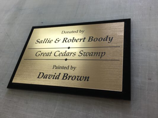 A Metallic Plaque in Gold Tones on a Board