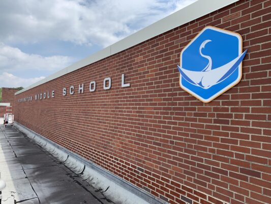 A Middle School Sign Placed on a Brick Wall